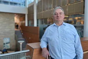 A man leans against a railing