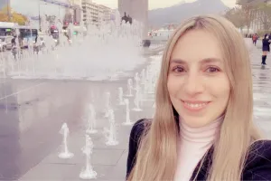 A woman stands in front of a water fountain