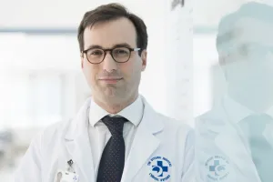 Man in lab coat looks at camera