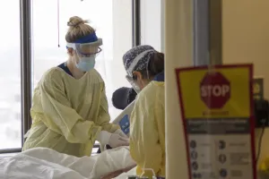 Nurses care for a patient in the ICU