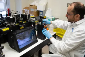 Man in lab coat operates a flow cytometer