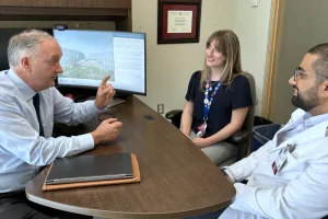 Three people meeting around a table