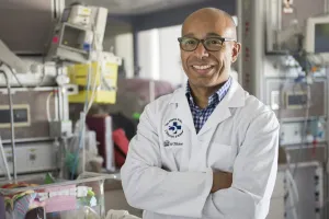 Man in lab coat stands in NICU
