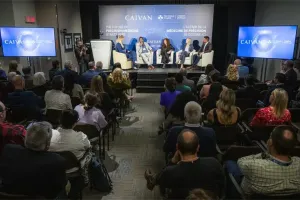 An audience watches a panel presentation