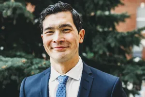 Man in suit smiles at camera
