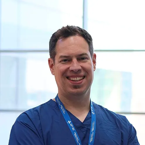 A man looks at the camera, smiling