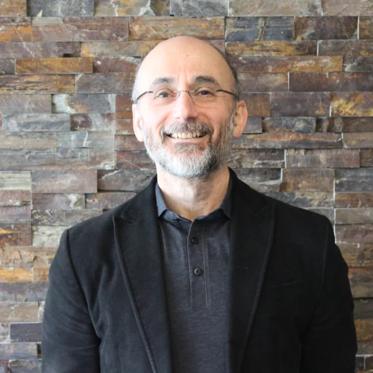 Man in jacket smiles at camera