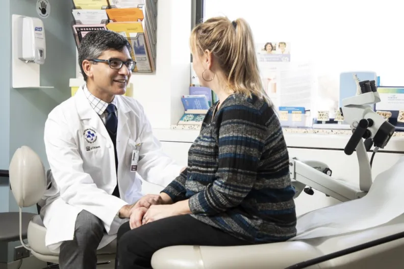 A doctor and patient talk in an exam room