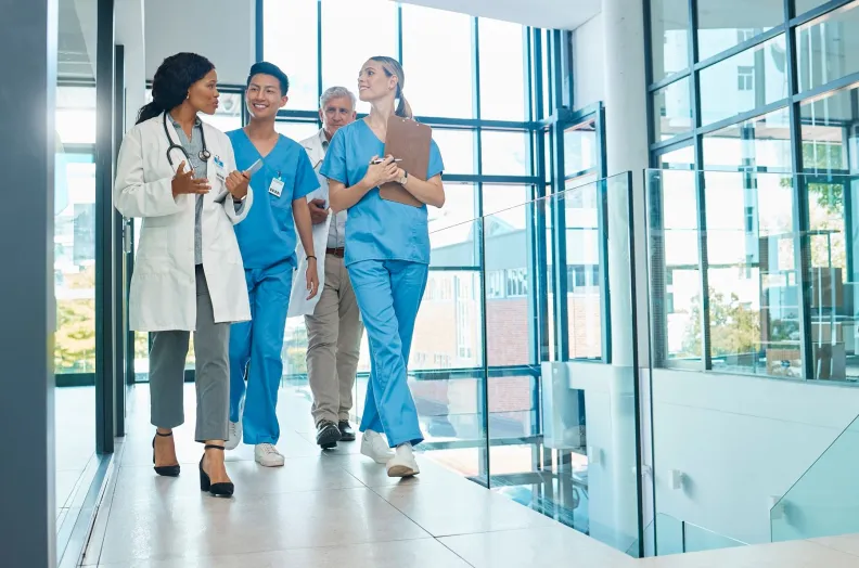 Clinical staff walk down a hospital hallway
