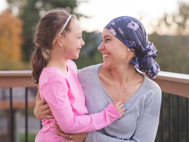 Une femme et un enfant s'enlacent et sourient
