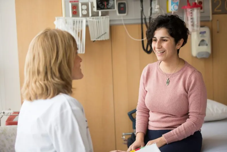 A patient and doctor talking in an exam room