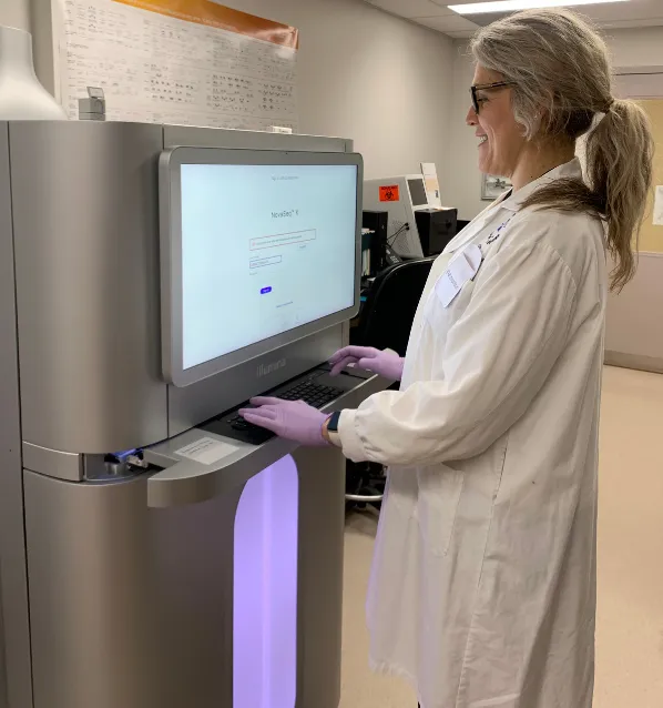 A Biomedical Technician works on teh NovaSeq X DNA sequencer at StemCore