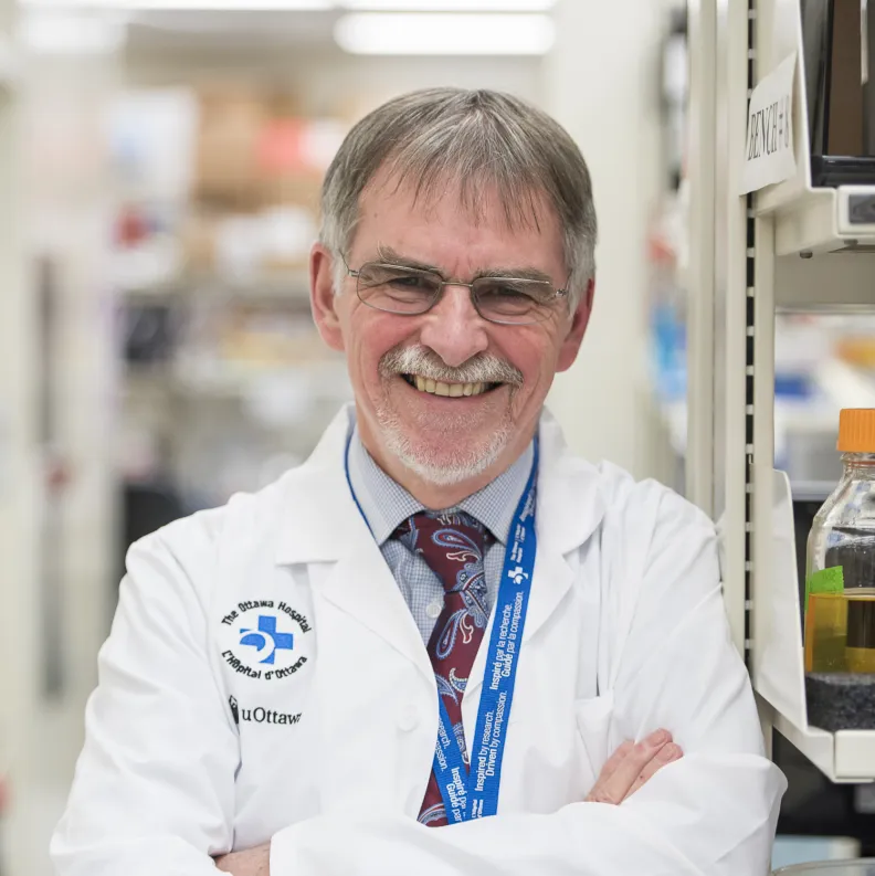 Man in lab coat looks at camera